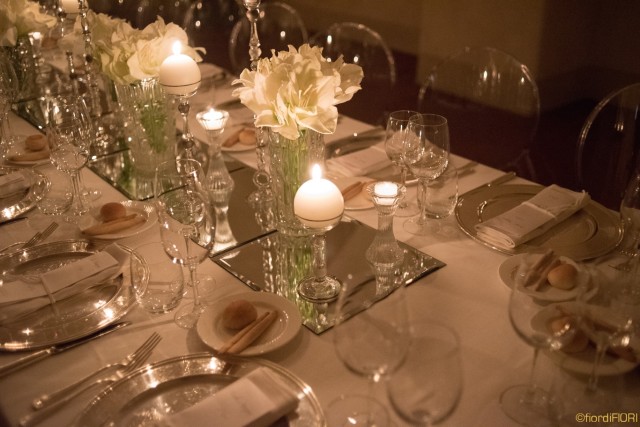 Tavolo imperiale con fiori bianchi e candele di varia forma e altezza
